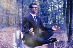 Man in a meditation pose practicing affirmations in the forest